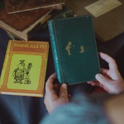 First edition Winne-the-Pooh being held with another book in background. Credit, 澳门七星图